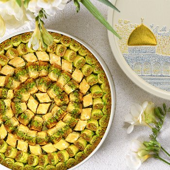 تصميم خارجي لعلبة بقلاوة من الأخوين زلاطيمو مزينة بقبة ذهبية وعبارة "رمزالعراقة"
