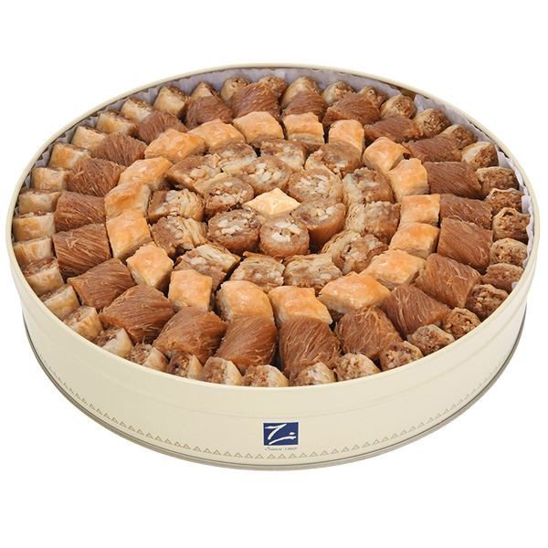 Traditional Arabic baklava, burma, and nut rolls in round tin – gourmet assortment
