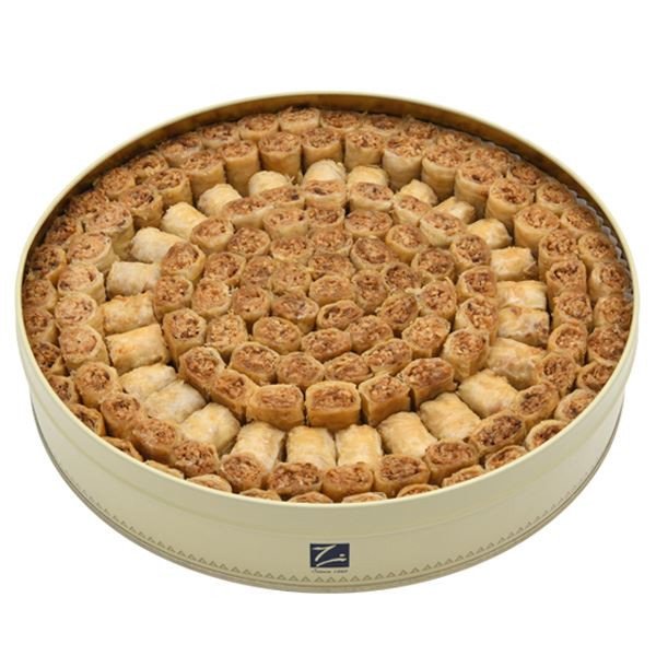 Middle Eastern baklava rolls with pine nuts and crushed mixed nuts in circular gourmet tin