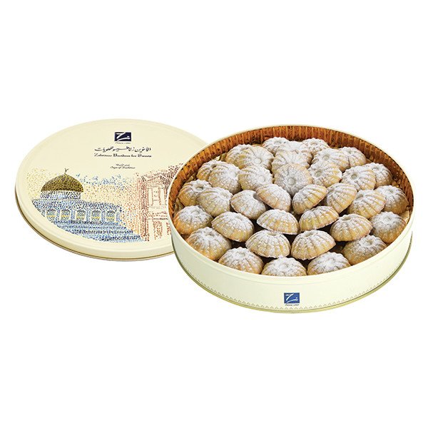 Zoomed-in image of handcrafted maamoul cookies with decorative clove tops arranged in a colorful circular tin.